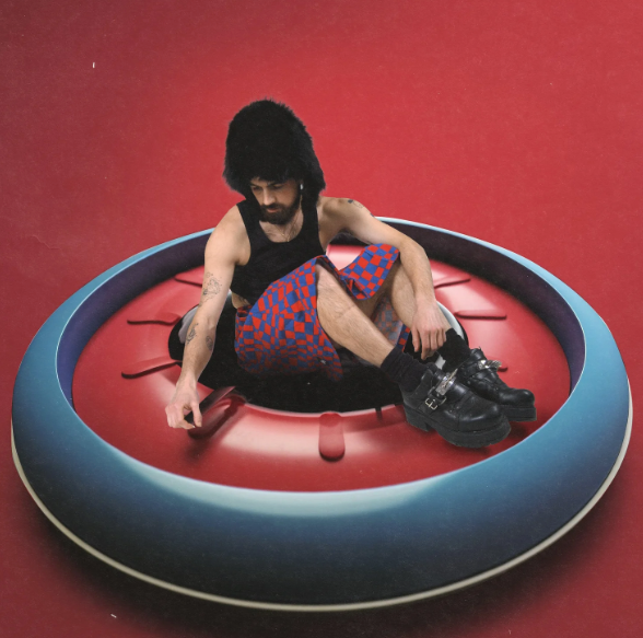 Person sitting inside a large inflatable ring on a red background