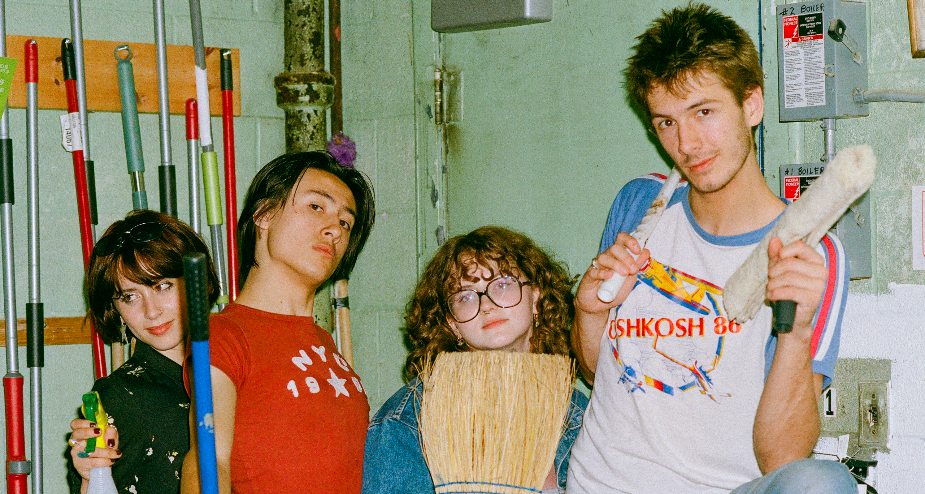 Four people in a room with cleaning supplies